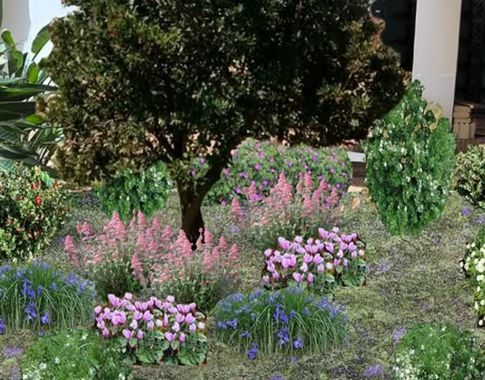 Jardín con un árbol central rodeado de flores rosas, moradas y azules, ideal para diseño paisajístico.